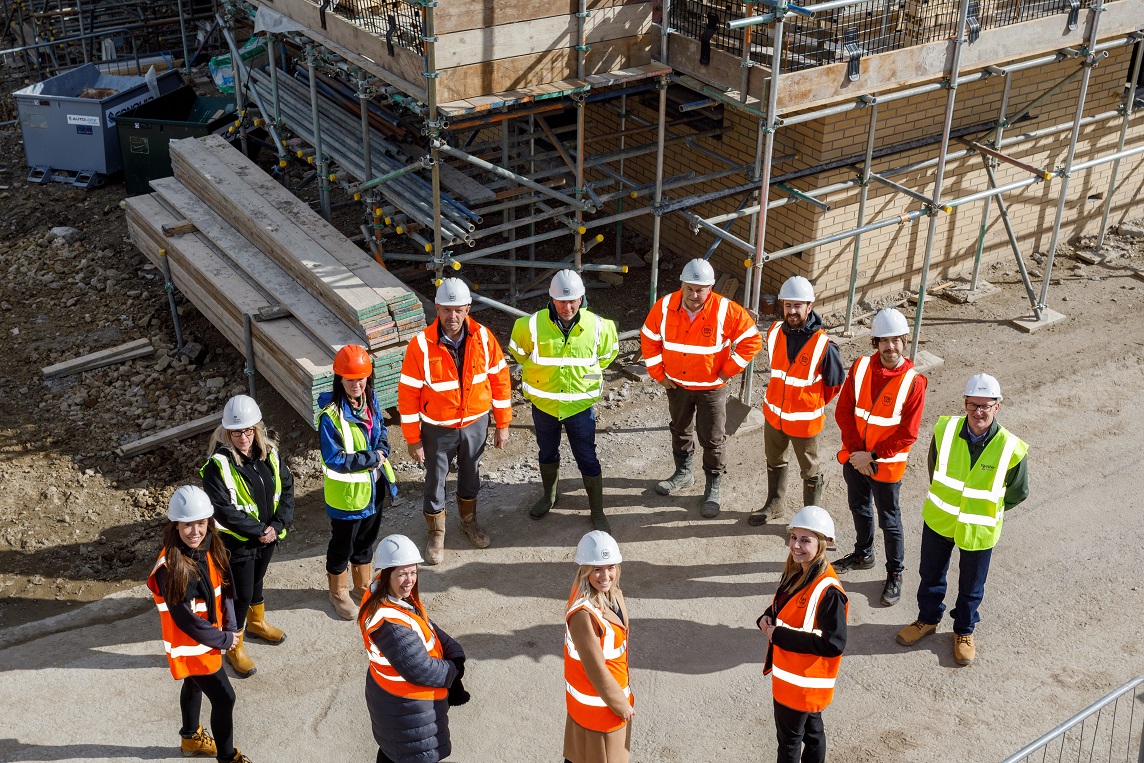 Group of wngineers standing in a circle wearing high viz