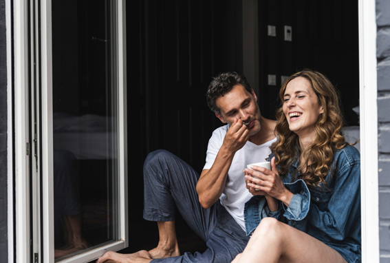 A man and a woman sitting by bi-fold doors