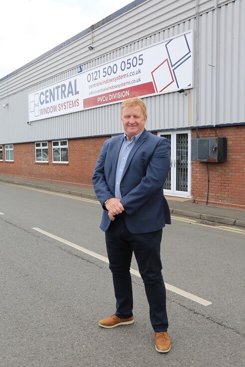 A man standing in front of a factory