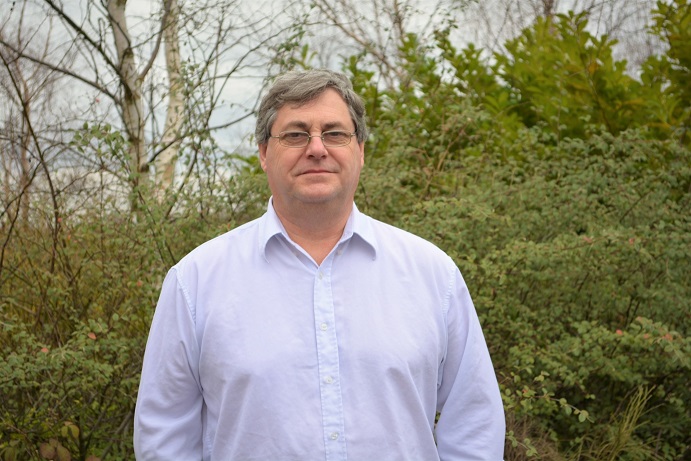 A man standing in front of some trees