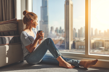 Lady with drink sitting by the window