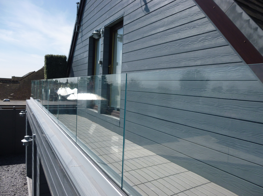 A grey clad house with a glass balustrade