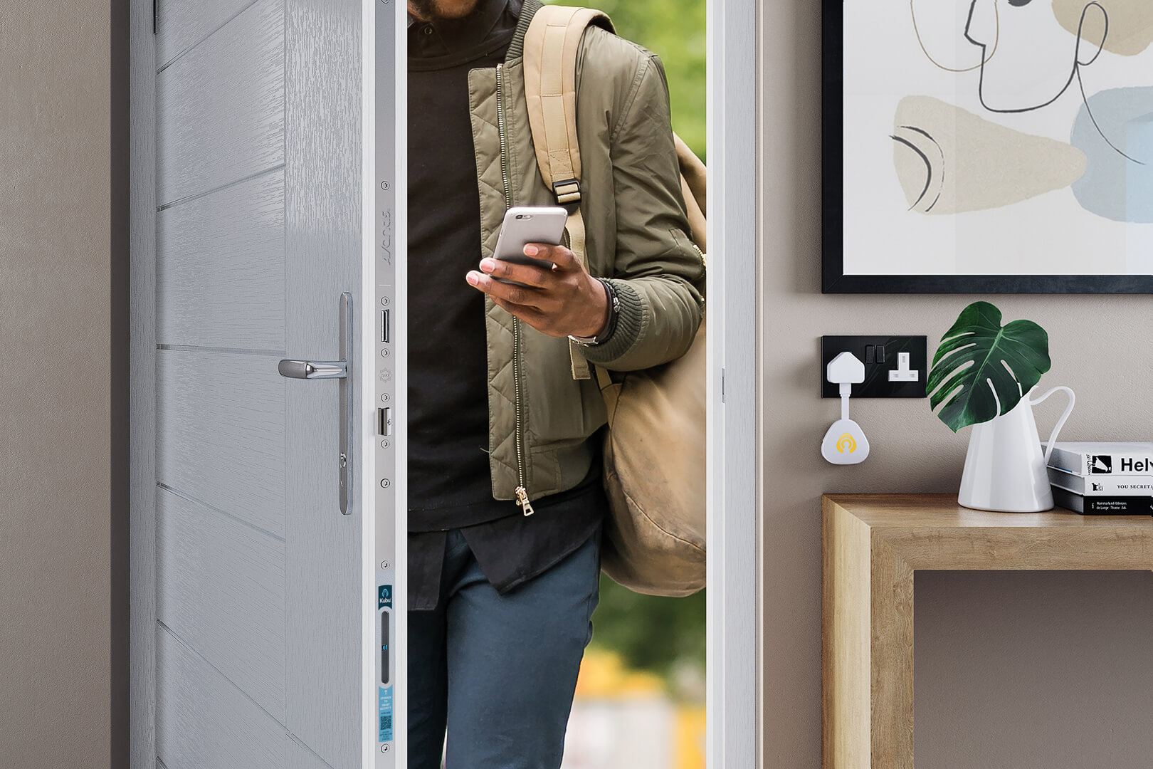 A man coming through a front door holding a smart phone