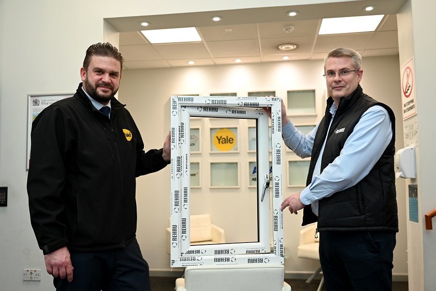 Two men holding a window in and office