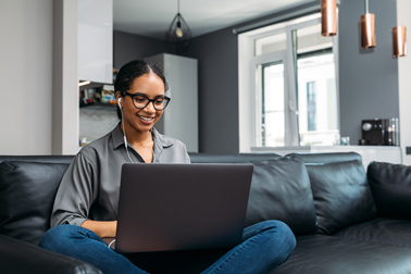 Woman working on a laptop on the sofa